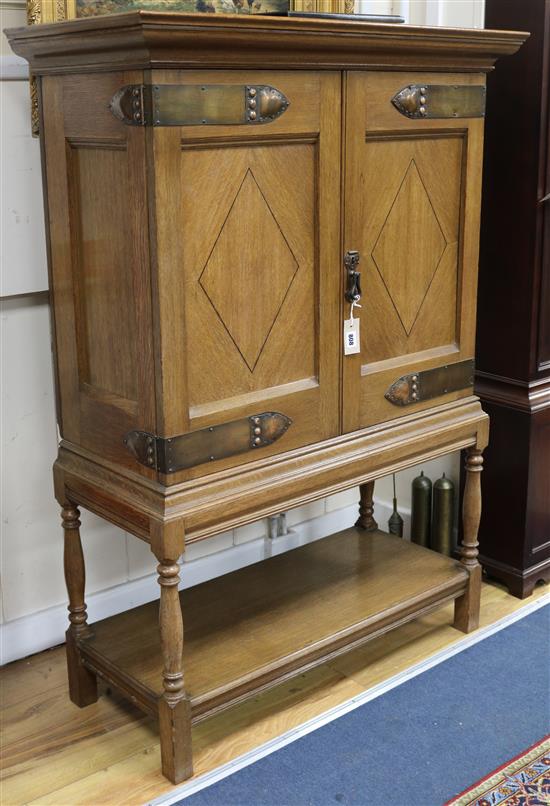 An Arts & Crafts inlaid oak cabinet, with copper mounts W.98cm